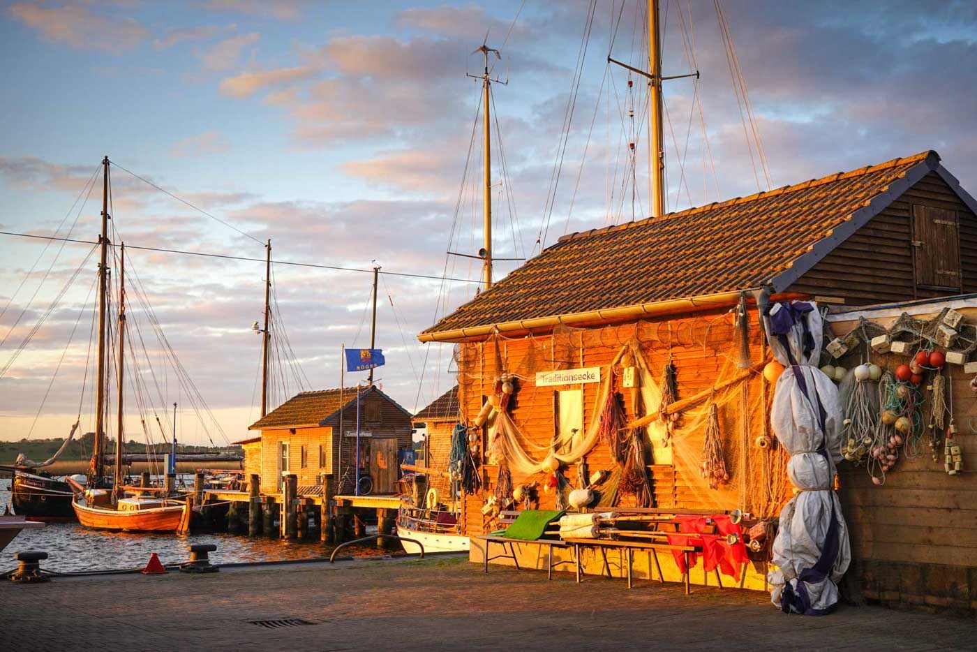 Mit Fischerei-Utensilien geschmücktes Bootshaus im Hafen von Gager Rügen